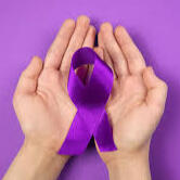 Image of hands holding a purple ribbon, which represents domestic violence awareness.
